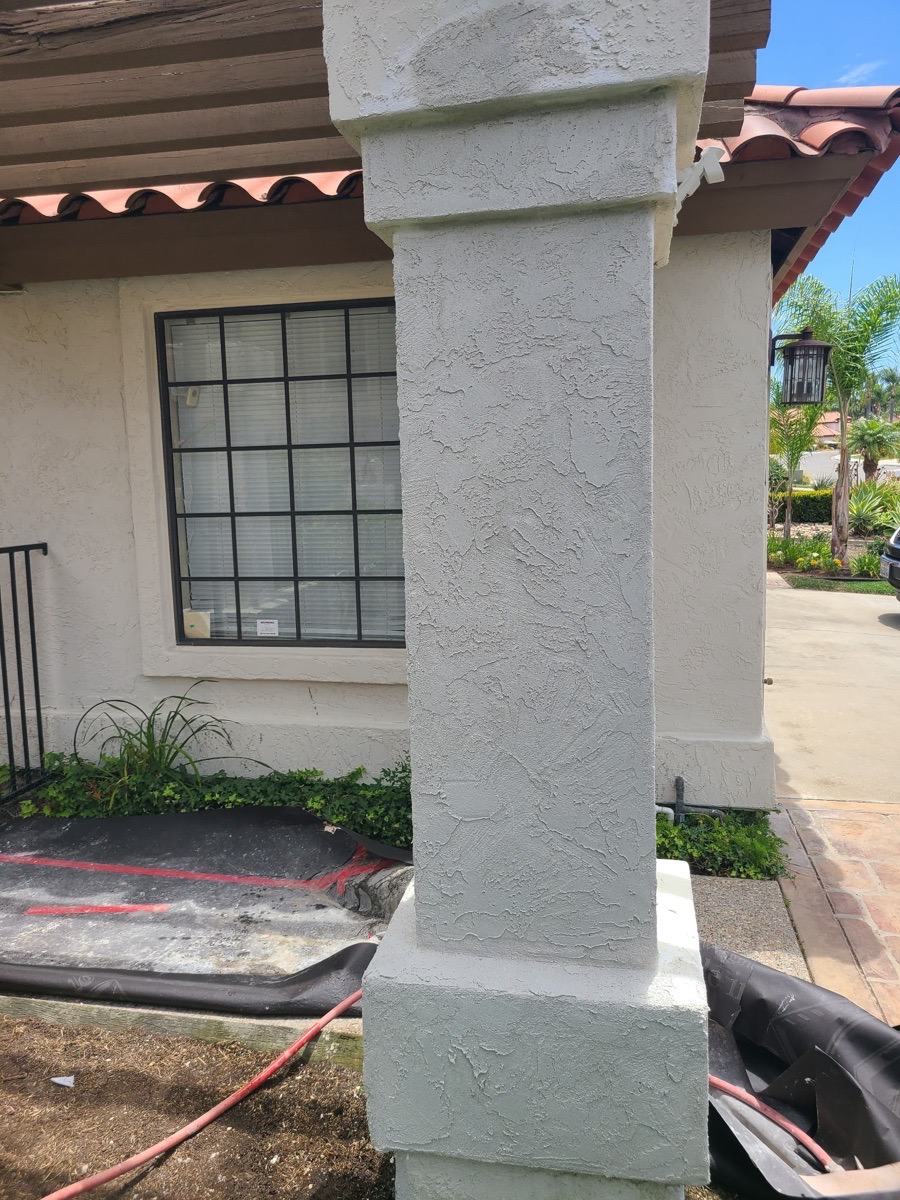 Localized stucco work-stage surface on an exterior pillar