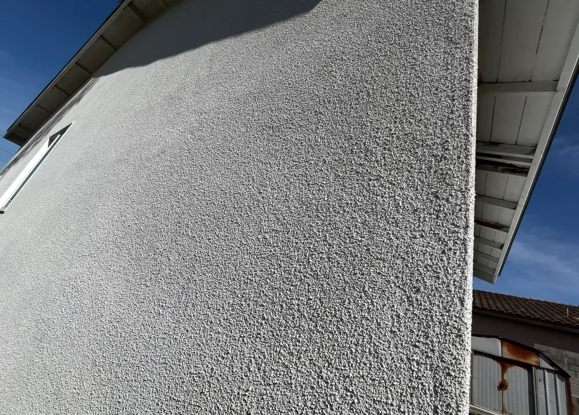 Close view of finished exterior stucco texture at a corner